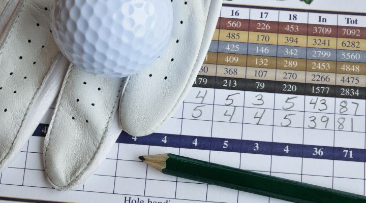 golf score card with glove, ball, and pencil